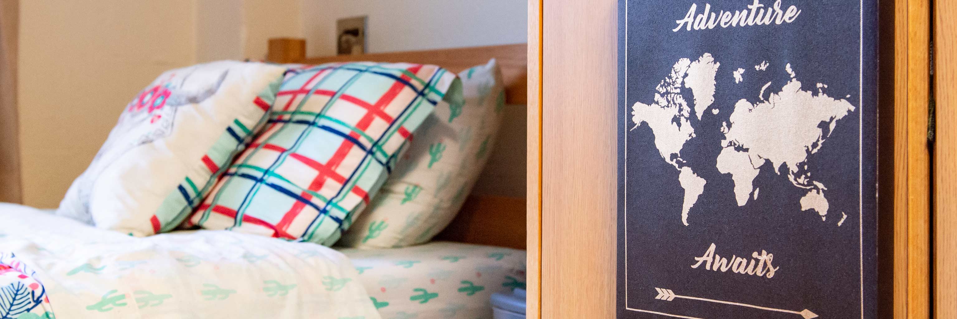 一张有装饰枕头的床，上面写着“冒险等待”