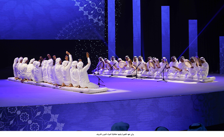 两行跪的人彼此面对舞台上沐浴在紫色的光。