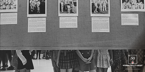 1970年的黑白图像显示图书馆井的小学学生观看展览